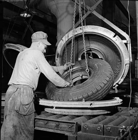Cet ouvrier de l’usine Société Polymer Limitée (Kitchener, Canada) retire un pneu en&nbsp;caoutchouc synthétique du four de vulcanisation, en octobre 1943. © BiobliArchives/LibraryArchives, Flickr, cc by 2.0