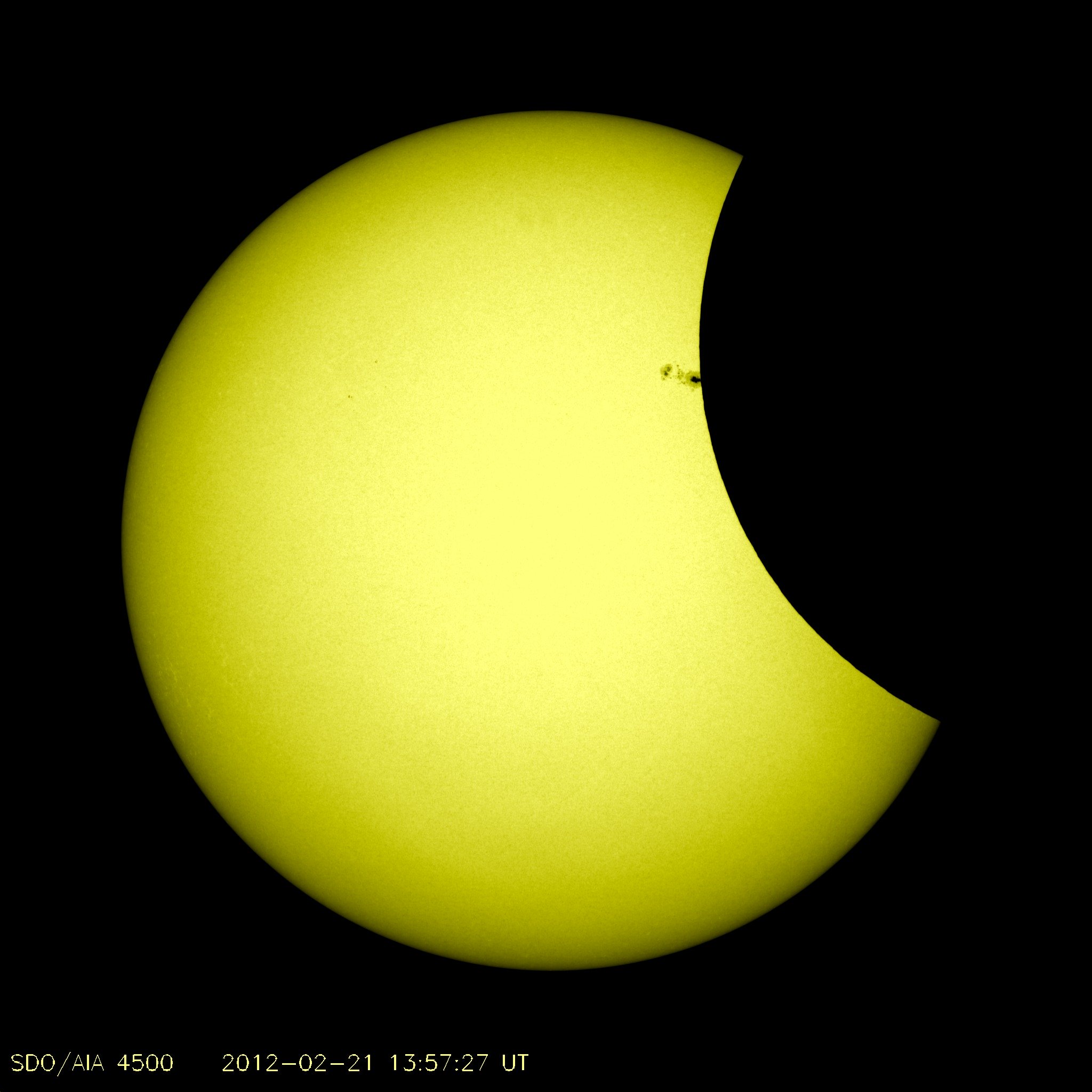 Pendant l'éclipse partielle du 21 février 2012, la Lune a brièvement masqué le groupe de taches solaires AR 1422, une occasion rare pour les scientifiques d'étudier la proportion des rayons UV émis par ces anomalies magnétiques. © Nasa/SDO
