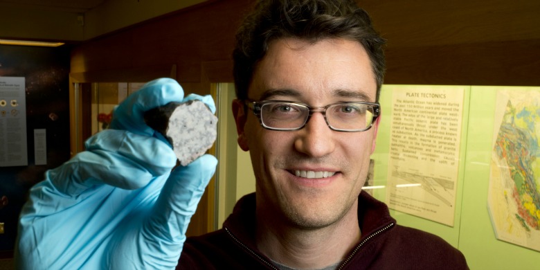 Chris Herd est le conservateur de la collection de météorites à l’Université de l’Alberta. Outre la minéralogie et la pétrologie, Chris Herd tient au premier rang de son carnet de recherche la planétologie comparative qui a pour but l’évaluation comparative d’échantillons de la terre avec ceux de Mars, de la Lune et d’une variété d’astéroïdes. On le voit ici tenir un fragment de la météorite de Tissint. © University of Alberta-John Ulan