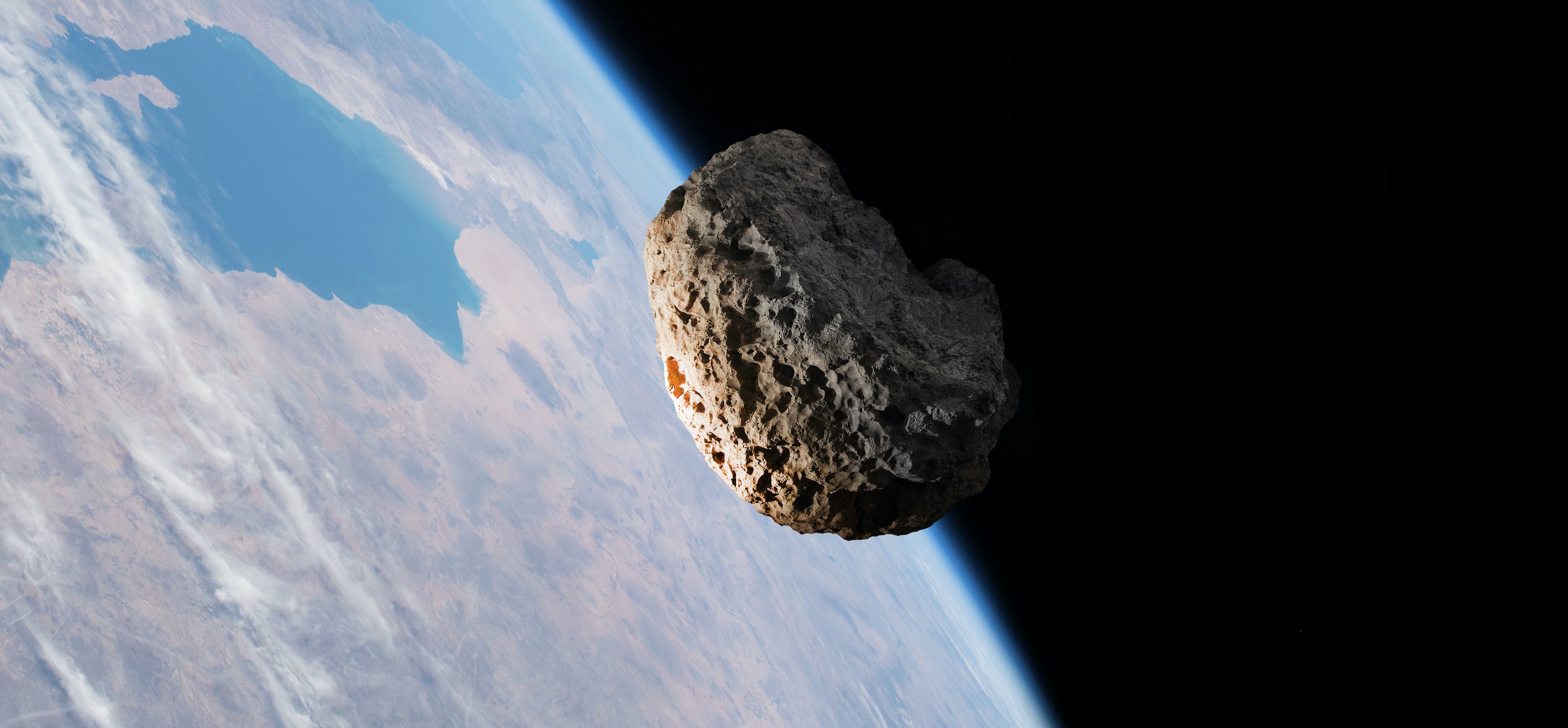 Illustration d'un astéroïde survolant la Terre. © tangoas, Adobe Stock