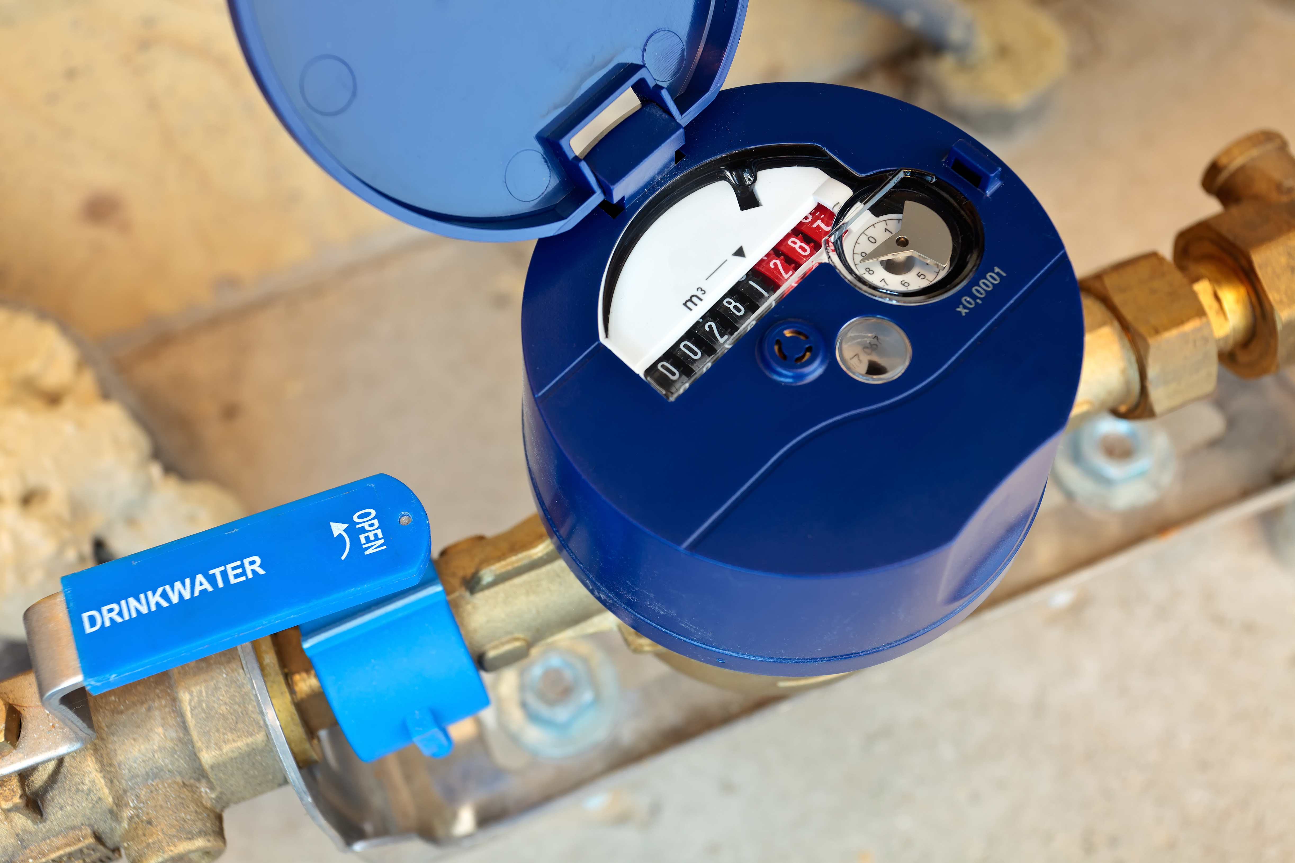 Le compteur d'eau permet de mesurer la consommation d'une installation. Il est équipé d'une vanne (poignée en bleu sur l'image mais le plus souvent rouge) pour permettre de couper l'arrivée d'eau si besoin. © Martin Bergsma, Adobe Stock