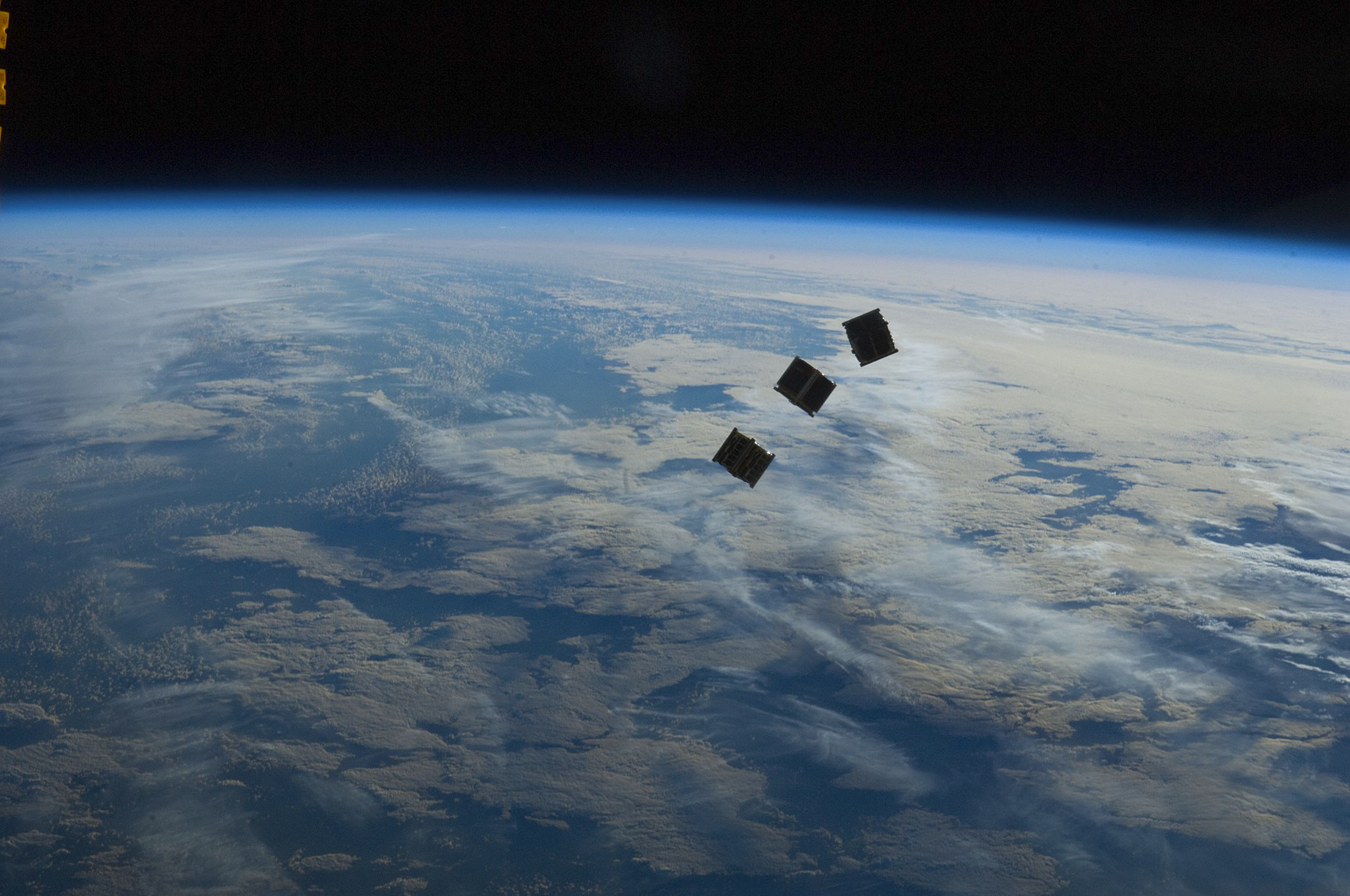 Trois petits CubeSats « lancés »&nbsp;depuis la Station spatiale internationale. Latitude, une start-up française développe un nano-lanceur adapté à la taille de ces très petits satellites qui pourra les lancer depuis la Terre. © Nasa