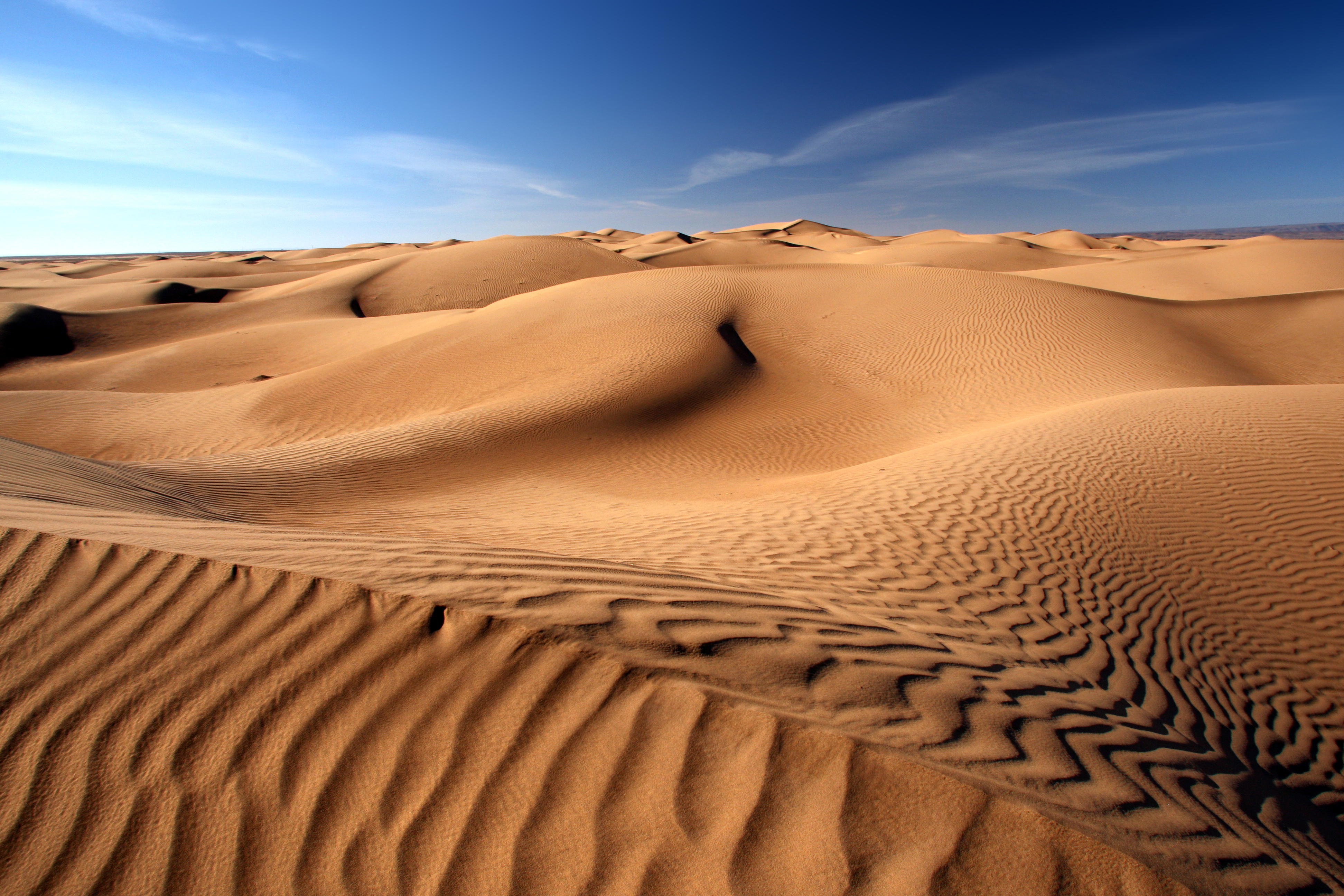 Le principe de la relation entre le nombre d'onde et la longueur d'onde peut-être utilisé pour étudier les ondulations sur les dunes du désert, et la façon dont elles se forment et évoluent sous l'action du vent. En mesurant la longueur d'onde et l'amplitude de ces ondes stationnaires, on peut prévoir les mouvements de sable dans le désert et protéger les infrastructures et les habitations contre les effets des dunes. © khorixas, Adobe Stock