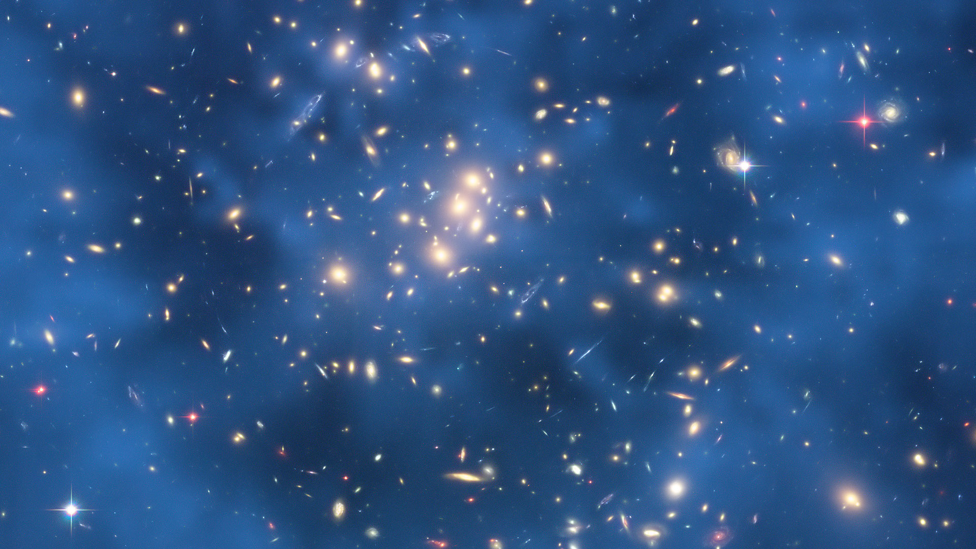 lentille gravitationnelle dans 0024 1654. Image prise par le HST de l'amas 0024 1654. Les objets bleus sont des images multiples d'une galaxie située loin derrière l'amas. C'est un exemple de lentille gravitationnelle