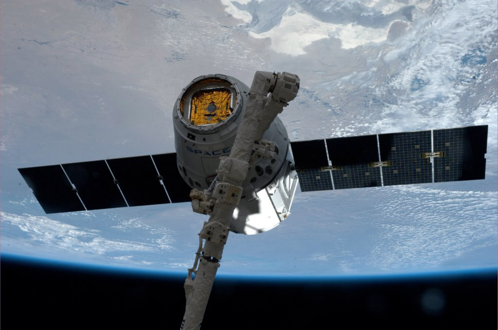 Saisie par le bras robotique de la Station spatiale internationale, la capsule Dragon de SpaceX est amarrée au module Harmony de la partie états-unienne de l'ISS. © Nasa