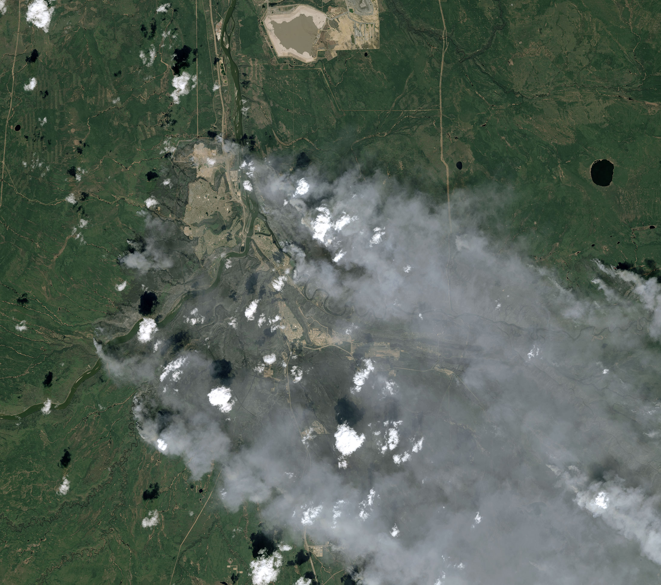 Cette image satellite, acquise par le satellite Spot 7 le 6 mai dernier, offre une grande emprise et une résolution de 1,5 mètre. Elle montre une partie de la ville de Fort McMurray, au Canada, cernée par les incendies (les zones brûlées apparaissent en gris). © Airbus DS 2016