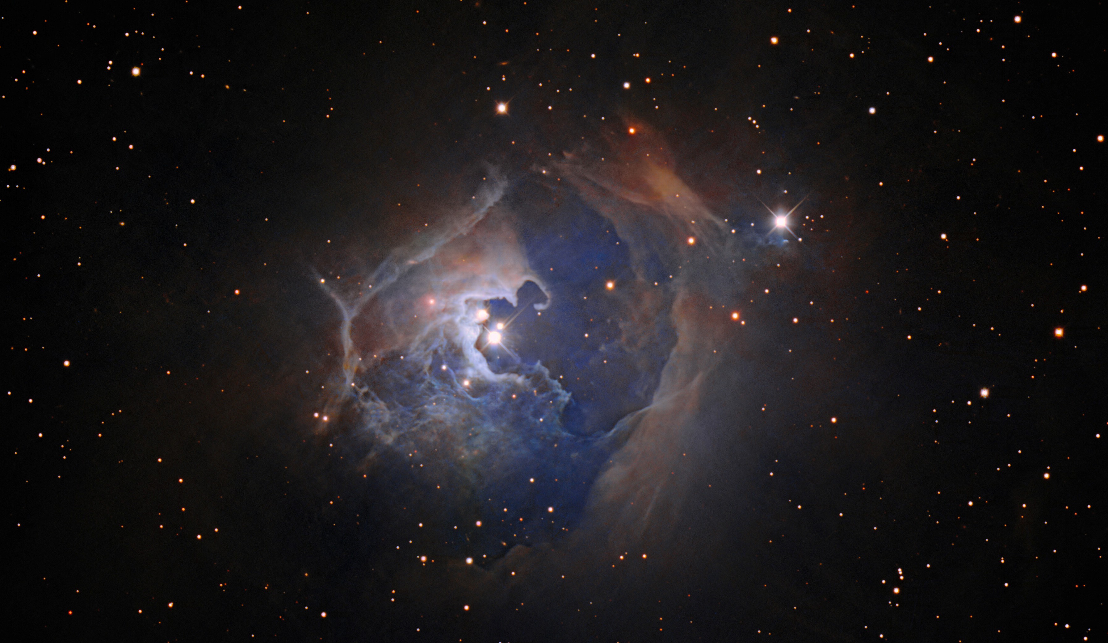 Cette observation capture l'étoile variable HP Tau, située à plus de 550 années-lumière de la Terre dans la constellation du Taureau. Cette image a été créée à l’aide des données du télescope Nicholas U. Mayall de quatre mètres de l’observatoire national de Kitt Peak (KPNO). HP Tau est une étoile T Tauri, un type d'étoile jeune et chaotique qui s'installe dans une phase plus calme de la vie stellaire connue sous le nom de séquence principale. Le temps qu’une étoile passe sur la séquence principale dépendra de sa masse. Notre Soleil, par exemple, est à environ la moitié de la durée de vie de sa séquence principale, d'environ 10 milliards d'années. HP Tau fait partie d'un système à trois étoiles (les trois étoiles distinctes sont visibles au centre de cette image) entouré d'une grande nébuleuse par réflexion en arc. Ces nébuleuses, comme leur nom l'indique, réfléchissent la lumière des étoiles proches plutôt que de briller comme les nébuleuses par émission ailleurs dans l'Univers. © KPNO/NOIRLab/NSF/AURA/T.A. Recteur (NOIRLab de l’Université d’Alaska à Anchorage/NSF). Traitement d'images : T.A. Recteur (NOIRLab de l’Université d’Alaska à Anchorage/NSF), M. Zamani (NOIRLab de NSF) et D. de Martin (NOIRLab de NSF)