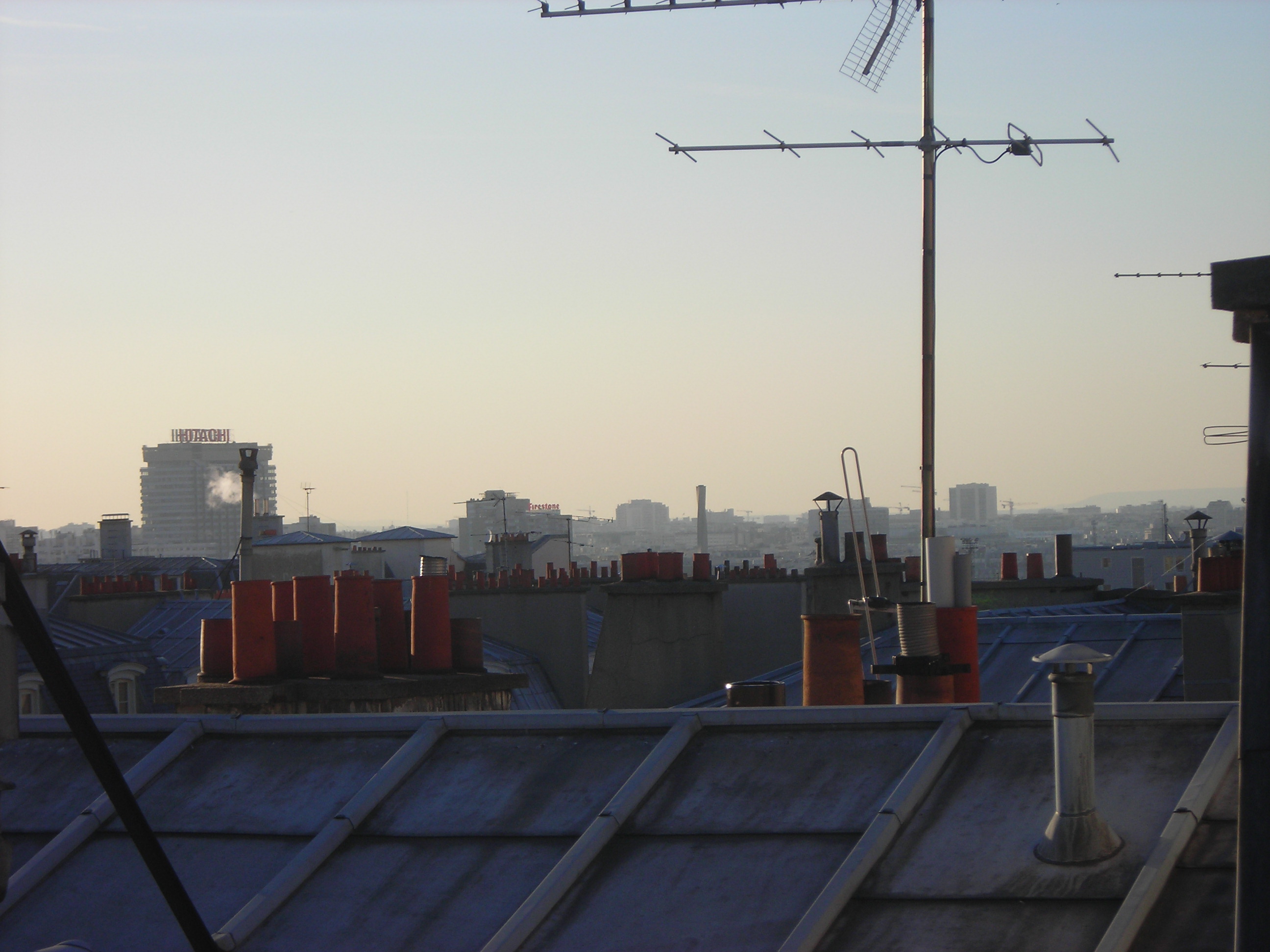 L'arêtier désigne une ligne rampante se trouvant au point d'intersection saillant de deux pans de toiture. Sur cette photo des toits de Paris, on voit au premier plan un arêtier recouvert d'une bande métallique. © Dorian Bianco, Domaine public, Wikimedia Commons