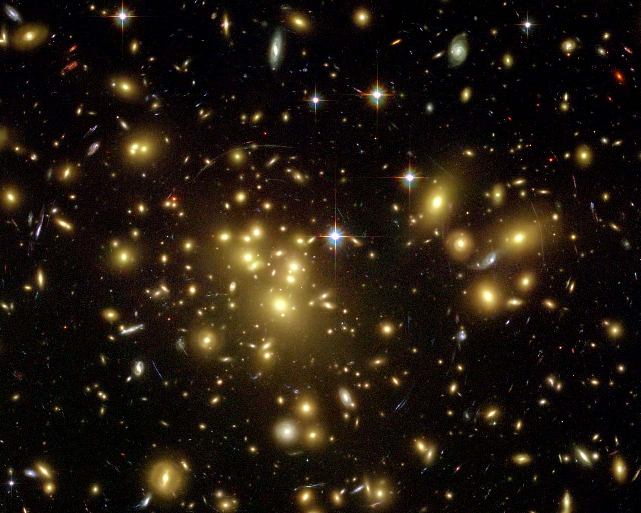 Abell 1689 est un amas de galaxies dans la constellation de la Vierge. C'est l'un des plus grands amas et un des plus massifs avec effet de lentille gravitationnelle, trahissant la présence de matière noire. Il est distant de 2,2 milliards d'années-lumière et contient environ 1.000 galaxies. © Nasa