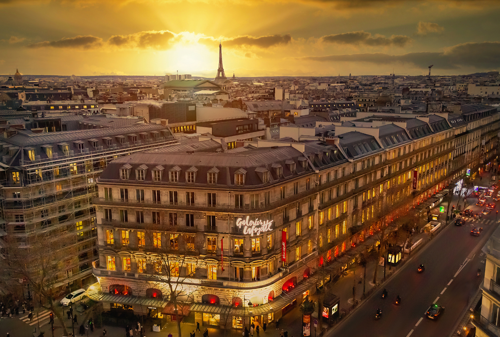 Les Galeries Lafayette et le soleil couchant à Paris avec la majestueuse Tour Eiffel en arrière-plan. © MarKord, Adobe Stock