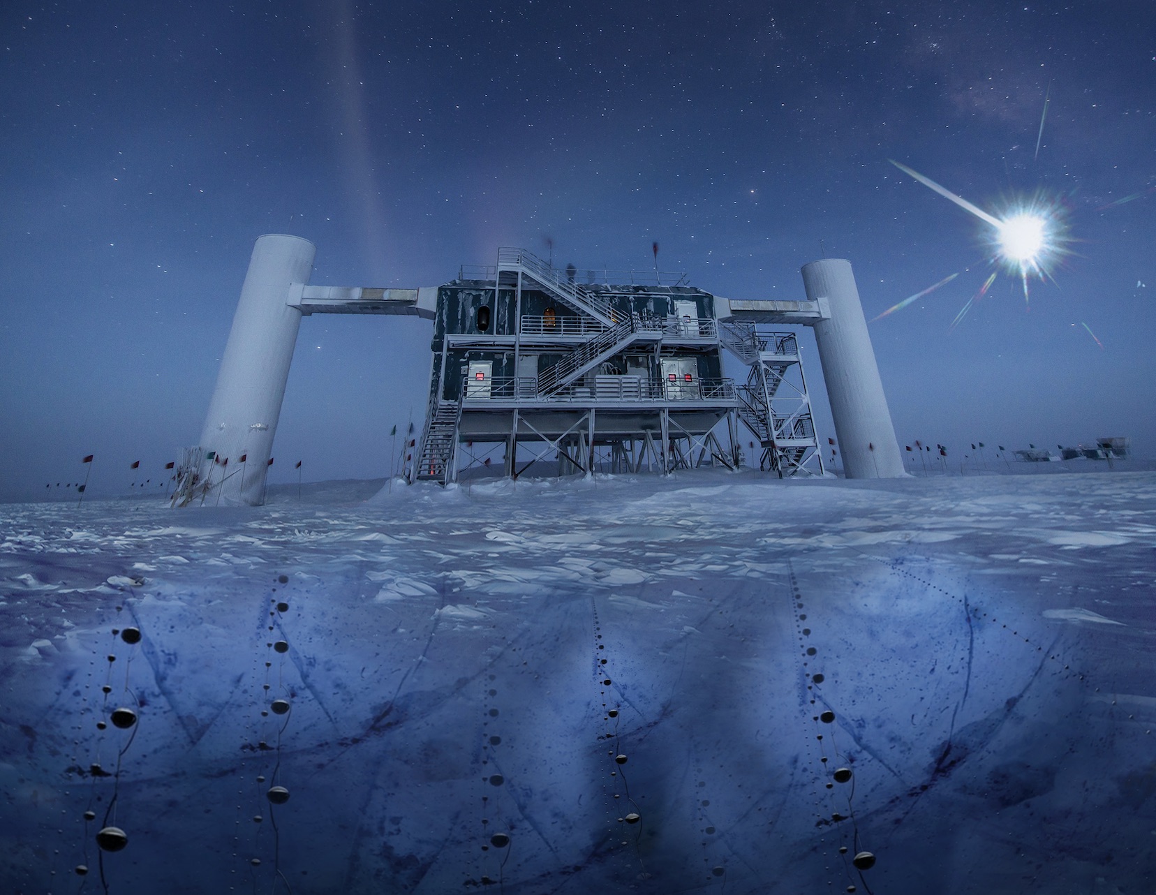 Une vue des bâtiments de surface du détecteur géant de neutrinos IceCube, en Antarctique. La pureté de la glace à plus d’un kilomètre de profondeur permet à plus de 5.000 photomultiplicateurs d'enregistrer avec précision les flashs bleutés, très ténus, générés par les muons issus de la collision des neutrinos avec les noyaux atomiques dans la glace. La construction de IceCube a commencé en 2005, mais le détecteur est une version plus grande d'Amanda qui date du début des années 1990. © Felipe Pedreros, IceCube, NSF