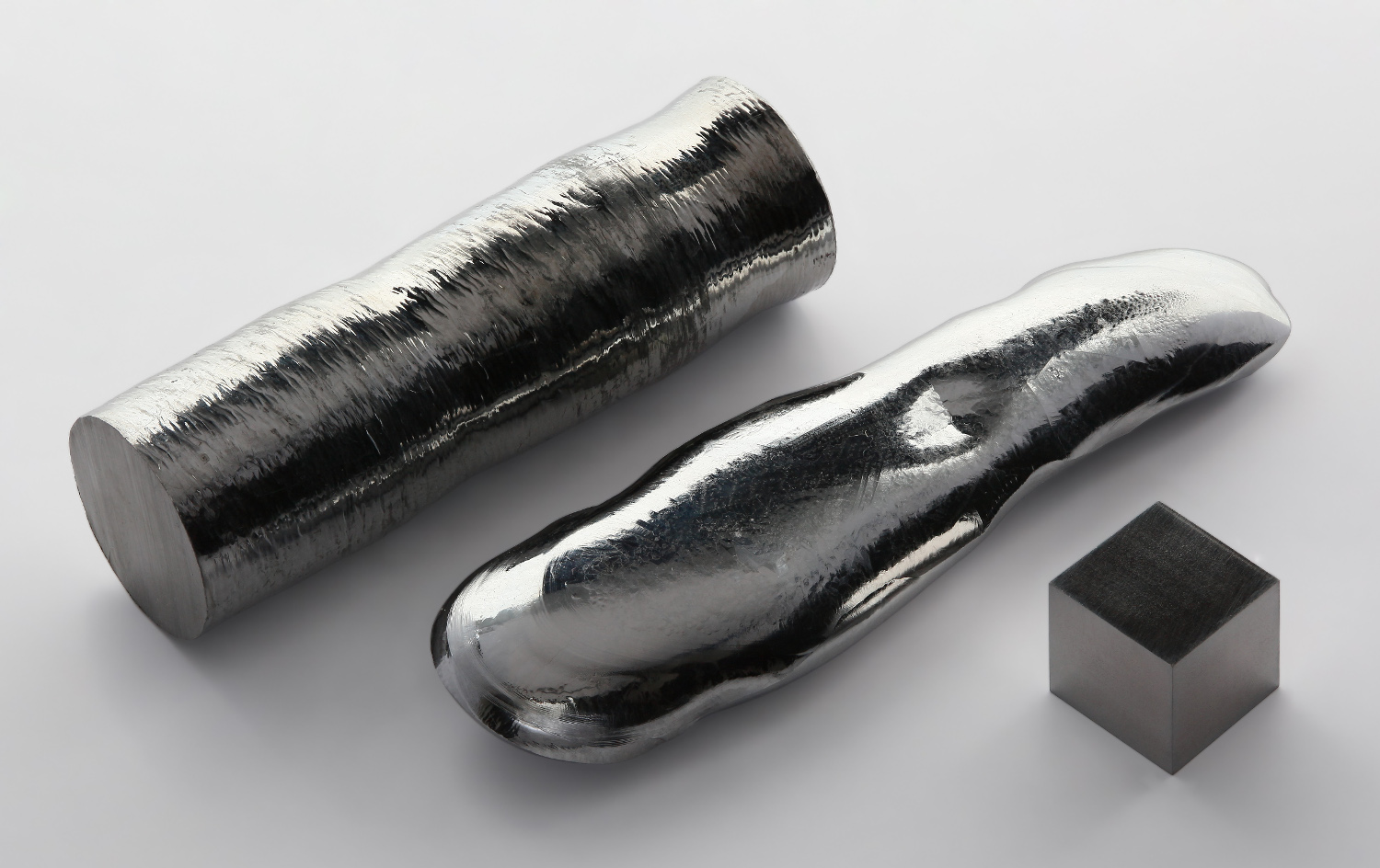 Le rhénium possède le point d’ébullition le plus élevé de tous les éléments chimiques. De gauche à droite : une barre de rhénium à 99,995 %, un monocristal de rhénium de haute pureté (99,999 %) produit par la méthode de la zone fondue et un cube de 1 cm de côté du même métal à (99,99 %). © Alchemist-hp, Wikimedia Commons, CC by-nc-nd 3.0