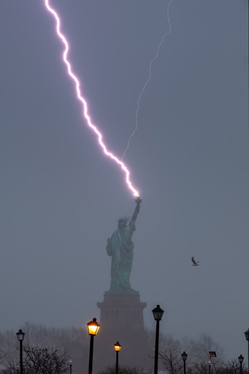 Le photographe américain a attendu des heures, pendant plusieurs jours, pour capturer cette photo parfaite d'un coup de foudre sur la torche de la Statue de la Liberté.  © Dan Martland