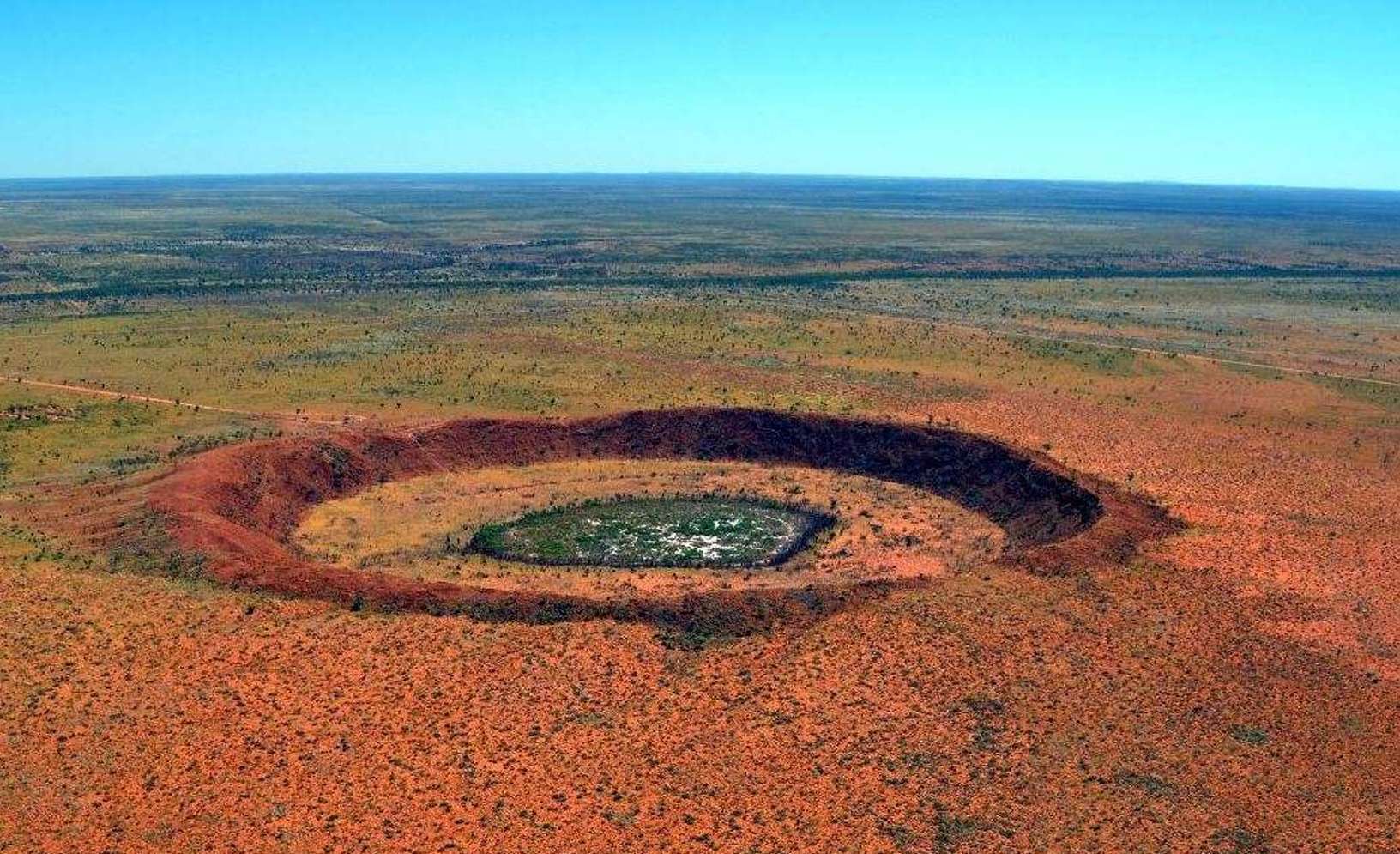 Le cratère de Wolfe Creek est un cratère météoritique situé dans l'État d’Australie-Occidentale. Il mesure 875 mètres de diamètre et 60 mètres de profondeur. L’impact serait survenu il y a moins de 300.000 ans au Pléistocène et c'est pourquoi il est facilement identifiable. Ce n'est pas le cas du double cratère d'impact supputé dans le bassin Warburton, en Australie-Méridionale, qui est quant à lui bien plus ancien. © Australia's North West