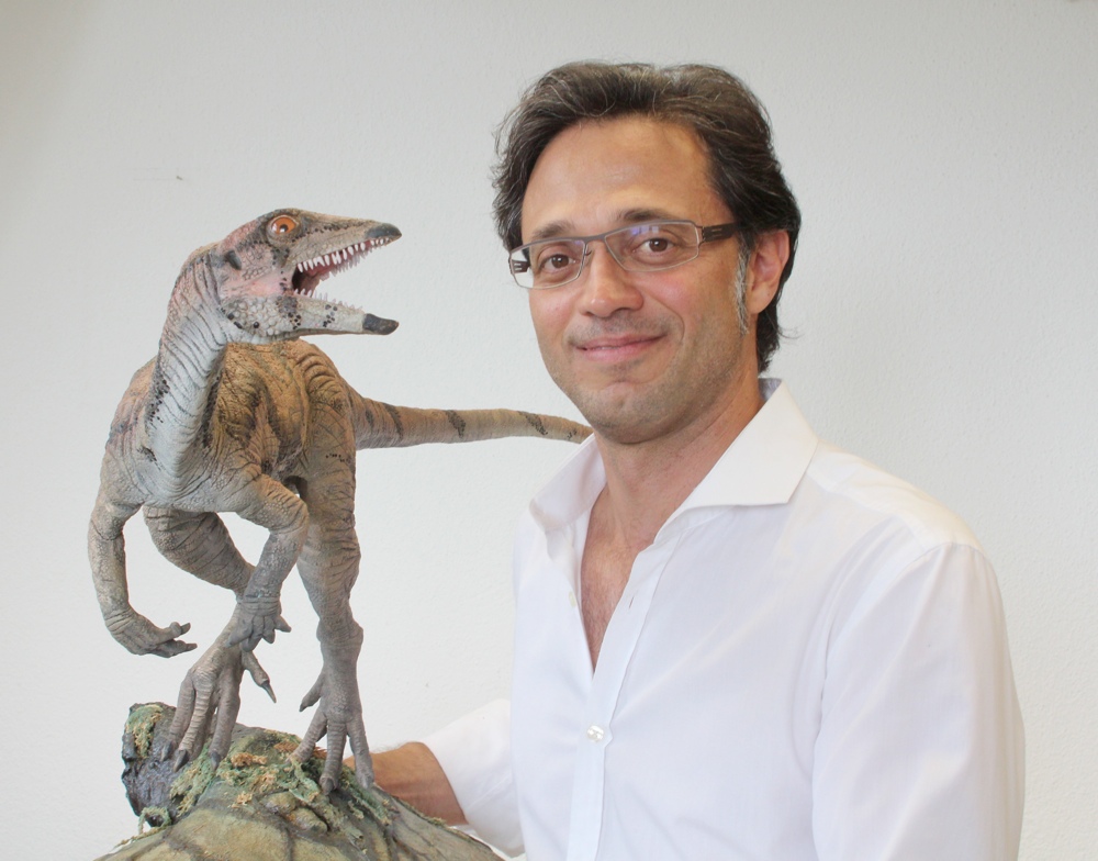 Marcelo Sánchez, professeur de paléontologie à l'université de Zurich, posant avec un modèle de Laquintasaura venezuelae. Le dinosaure ornithischien est à l'échelle. © Adrian Ritter/UZH