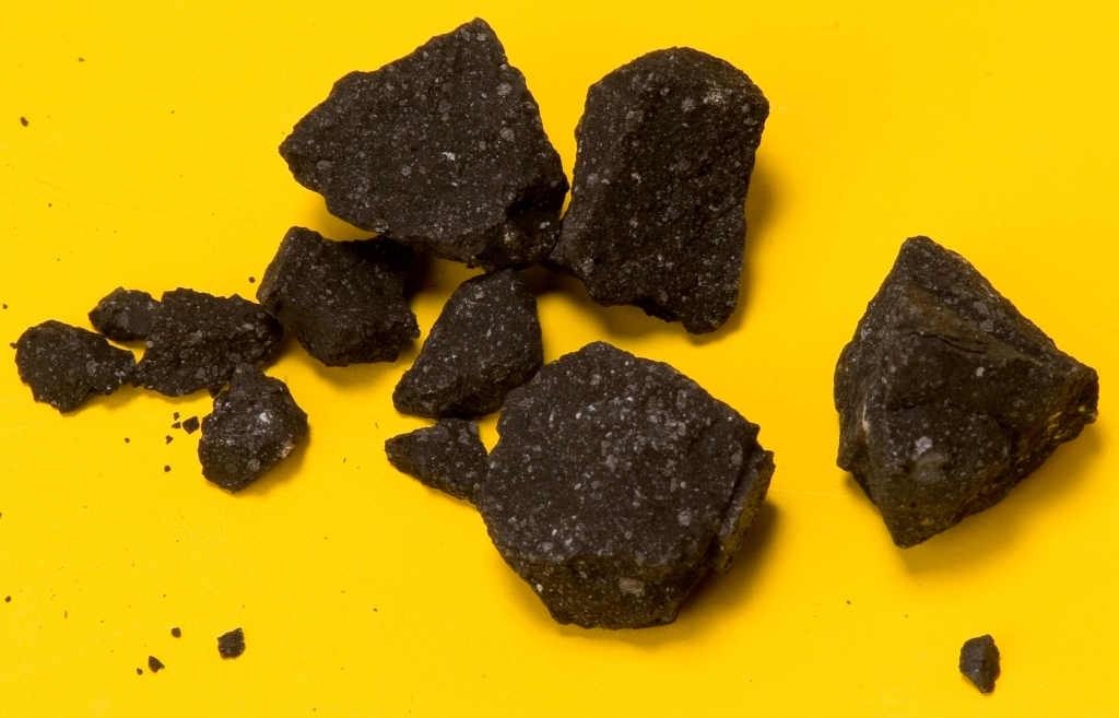 On voit ici des fragments de la météorite trouvée près de Sutter's Mill, en Californie. C'est une chondrite carbonée, dont les premières analyses ont montré qu'elle devait provenir de la surface d'un corps céleste probablement de nature intermédiaire entre astéroïde et comète. On vient d'y découvrir des molécules organiques inédites. Voilà de quoi éclairer, peut-être, les origines de la vie. © Arizona State University