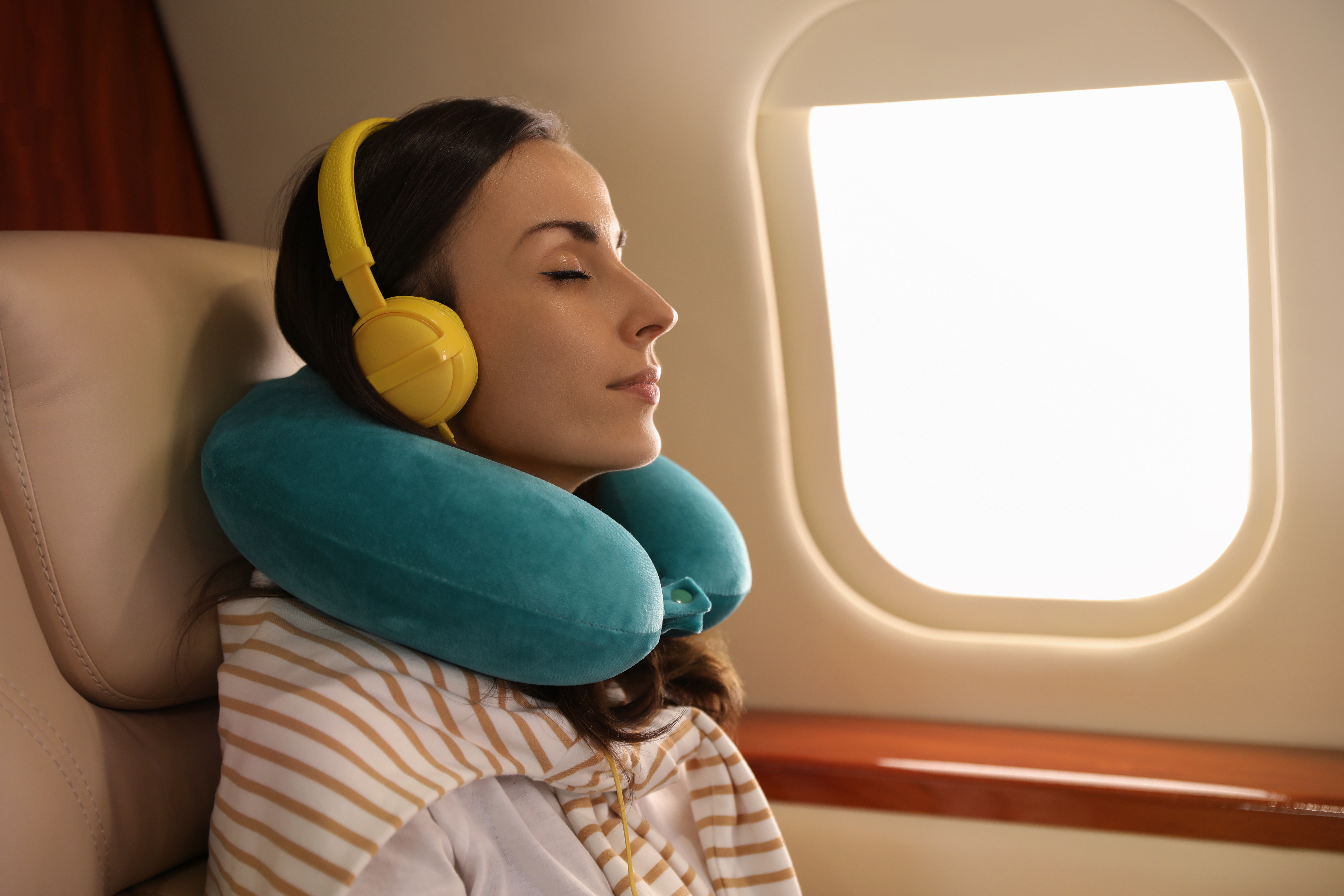 Un oreiller de voyage est indispensable pour des longs trajets en avion © New Africa, Adobe Stock