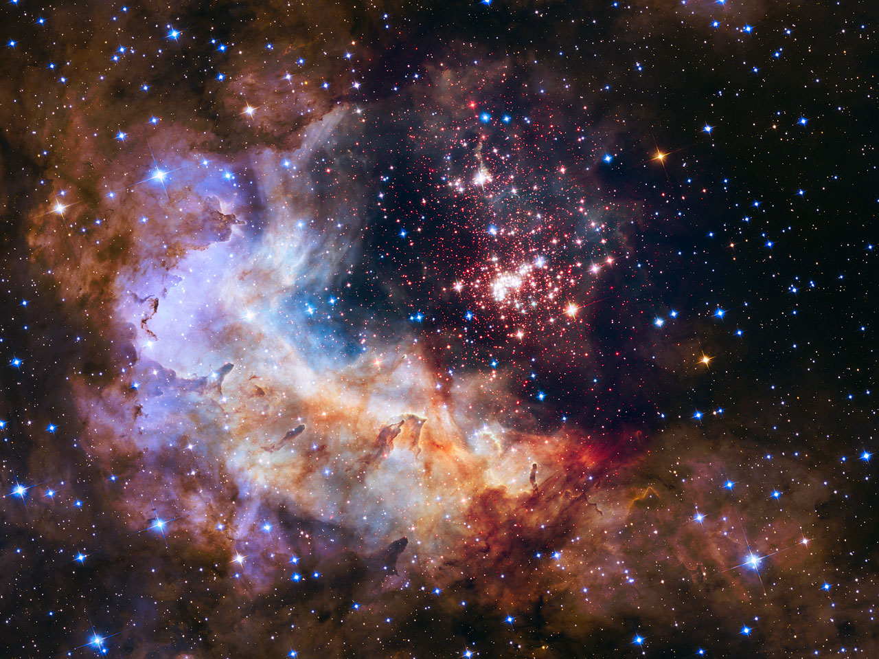 Dans la nébuleuse Gum 29 qui se profile devant l’essaim de jeunes étoiles Westerlund 2, se dressent des piliers de gaz hérissés, tous érodés par les vents violents des astres les plus massifs. Ce merveilleux tableau composite mélange des images prises dans le visible et le proche infrarouge avec les caméras ACS et WFC3 du télescope spatial qui fête, le 24 avril, ses 25 ans dans l’espace. © Nasa, Esa, the Hubble Heritage Team (STScI/AURA), A. Nota (ESA/STScI), the Westerlund 2 Science Team