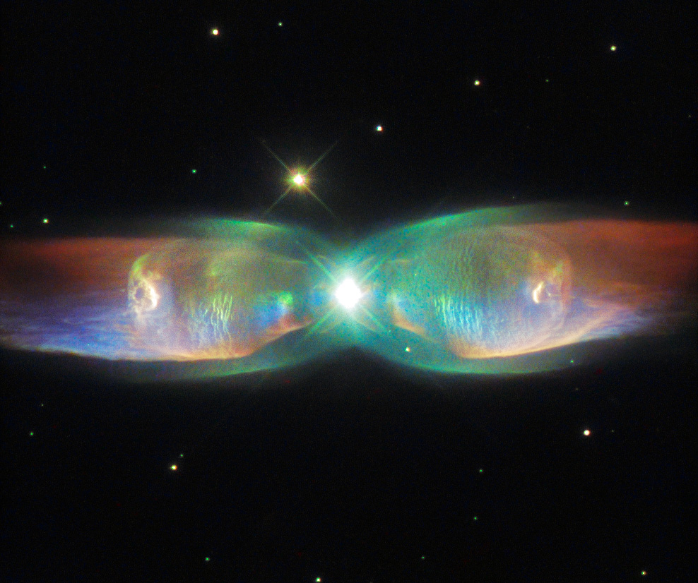 Il n’y a pas une mais deux étoiles en train de mourir au centre de cette nébuleuse planétaire nommée PN M2-9. Leur rotation l’une autour de l’autre, en cent 100 ans, créée la complexité des deux ailes de ce papillon. Téléchargez l’image en haute résolution ici. © Esa, Nasa, Hubble